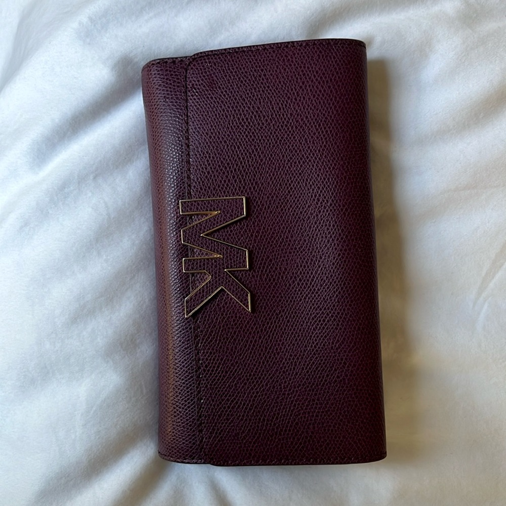 Michael Kors burgundy wallet with gold details.